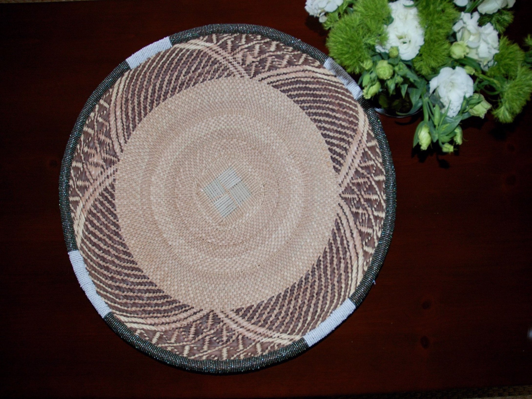 Medium handwoven basket with gray and white beading around the rim