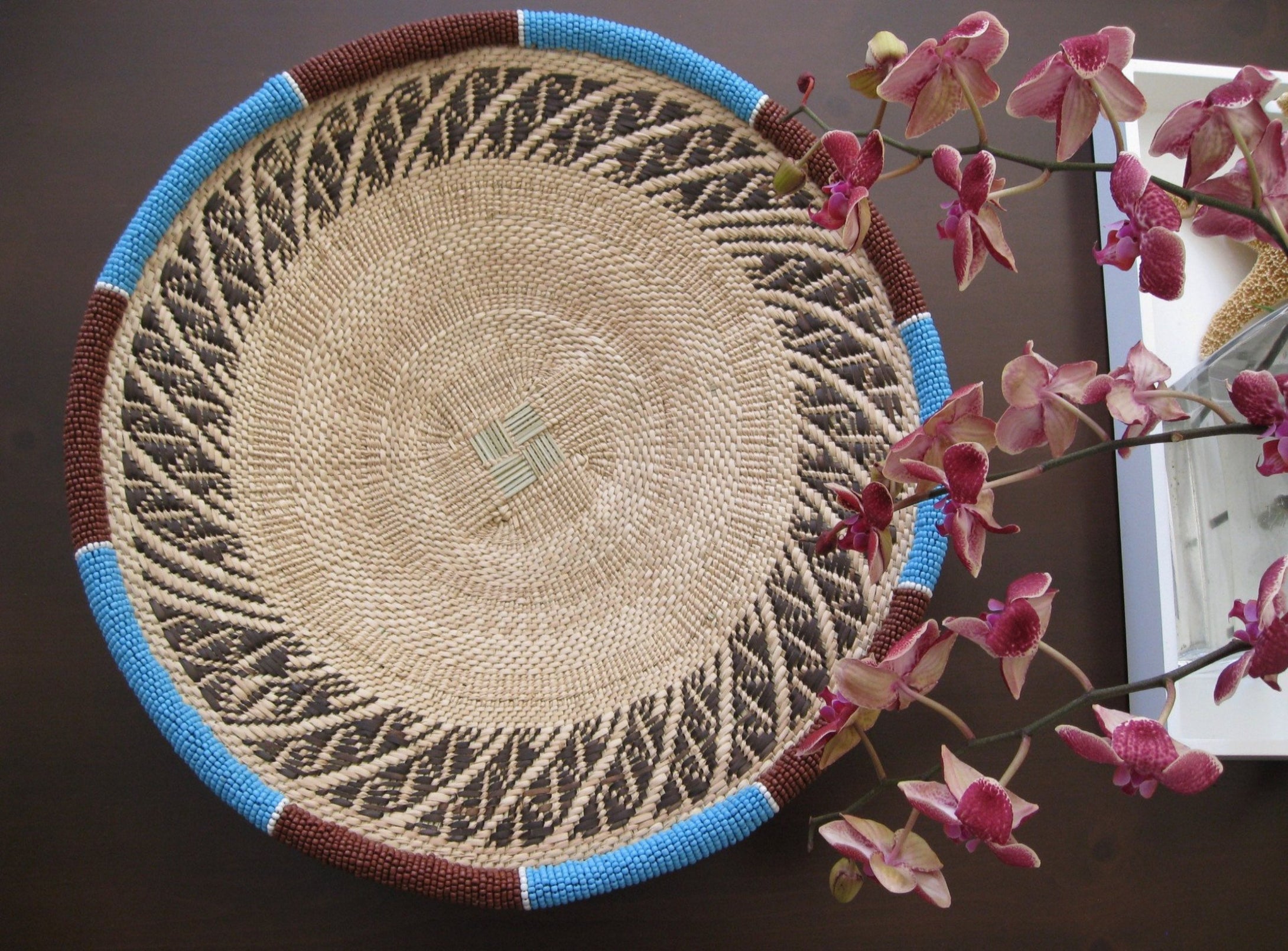 Medium handwoven basket with light blue and brown beads around the rim