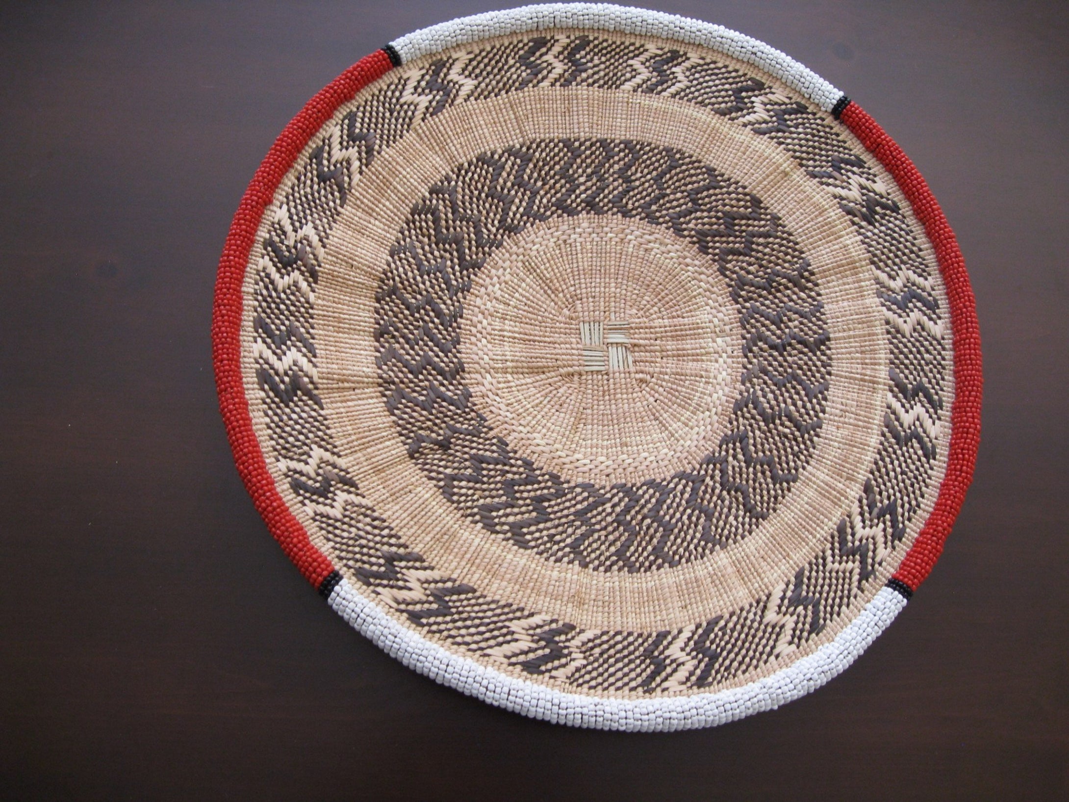 Medium handwoven basket with red and white beading around the rim
